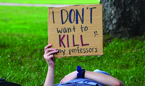 Student holding sign that says "I don't want to kill my professors"