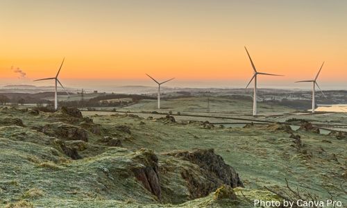 landscape shows a sunset with energy-generating windmills