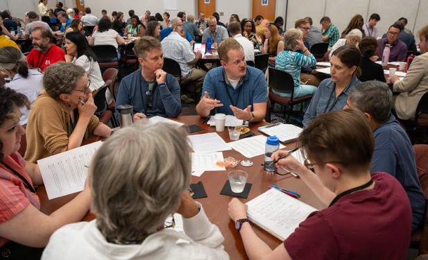 Faculty members sitting at tables talking